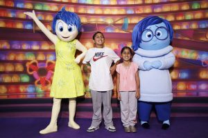 Two patients stand beside Inside Out 2 Characters 