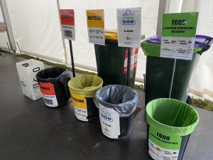 Waste disposal cans sit side by side, accompanied by signs indicating type of waste for sorting.