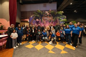 Make-A-Wish children and their families pose in front of a backdrop.