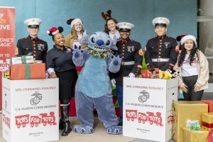 Stitch poses with Marines and Disney VoluntEARS