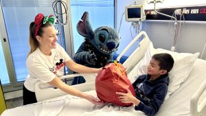 Stitch and Disney VoluntEAR hand toy to child patient