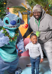 Stitch poses with a child and their father
