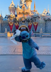 Stitch holds toilet paper in front of Sleeping Beauty Castle at Disneyland Resort