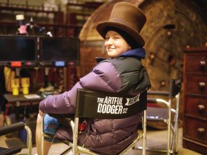 Remy sits on customized The Artful Dodger chair wearing top hat.