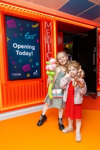2 kids stand by entrance of MediCinema