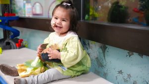 child smiling in Tiana Disney-themed hospital gown