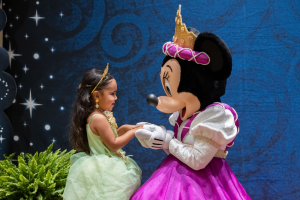 little girl holds hand with Princess Minnie Mouse