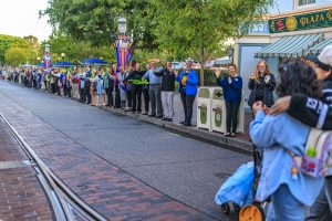 Lilo and her family walk down Main Street USA, lined by cast members cheering them on