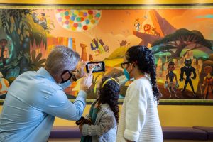 Disney and patients interact with Disney mural at CHLA