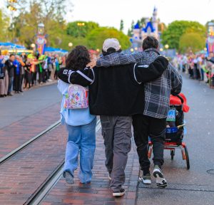 Lilo and her family walk down Main Street USA, lined by cast members cheering them on