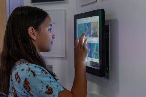 child swipes screen to select Disney character
