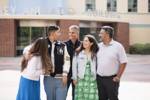 wish kid EJ stands in front of the Disney Animation building with his family and Disney CEO Josh D'Amaro