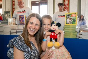 woman and little girl smile with mickey mouse plush
