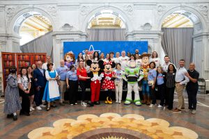 group photo with volunteers and Disney characters including Mickey Mouse, Buzz Lightyear and more