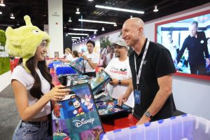 Starlight representative smiles while helping D23 guest pack a bag