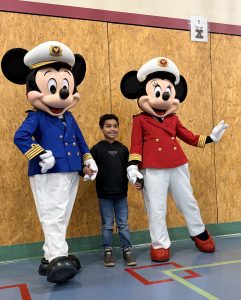 child stands posing with Captain Mickey and Captain Minnie