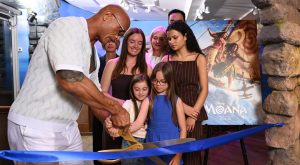 Dwyane the Rock Johnson cuts blue ribbon with a family