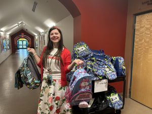 Disney VoluntEAR smiles and hold backpacks